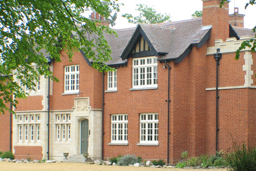 A large red brick house with sash windows in need of repairs located in Croydon.