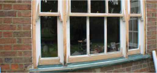 A picture of a window in a brick house undergoing restoration with sash windows.