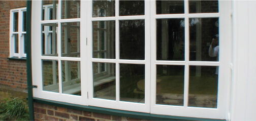 A restoration project focused on rejuvenating sash windows with a white frame and green trim.